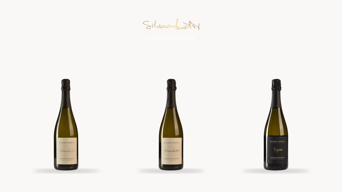 Three Silvano Zanetti Franciacorta DOCG bottles with the winery logo, on a plain cream background